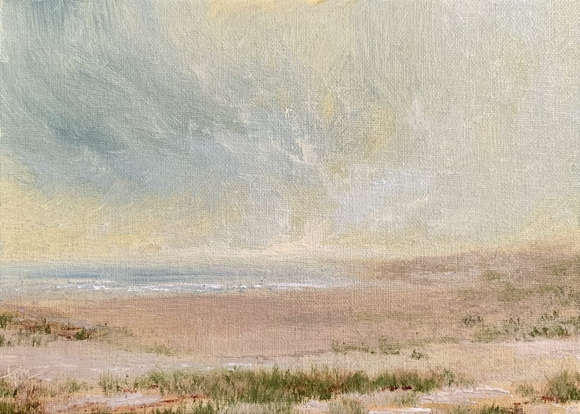 Photo of an original seascape oil painting by Tisha Mark, "When I Wake (Week 18, 52 Weeks of Finding Light Series)", 5"x7" oil on linen panel (2023). This is a soft, peaceful seashore scene at sunrise. The sky features soft yellows and blues, the shore has patches of sea grass among the sand.