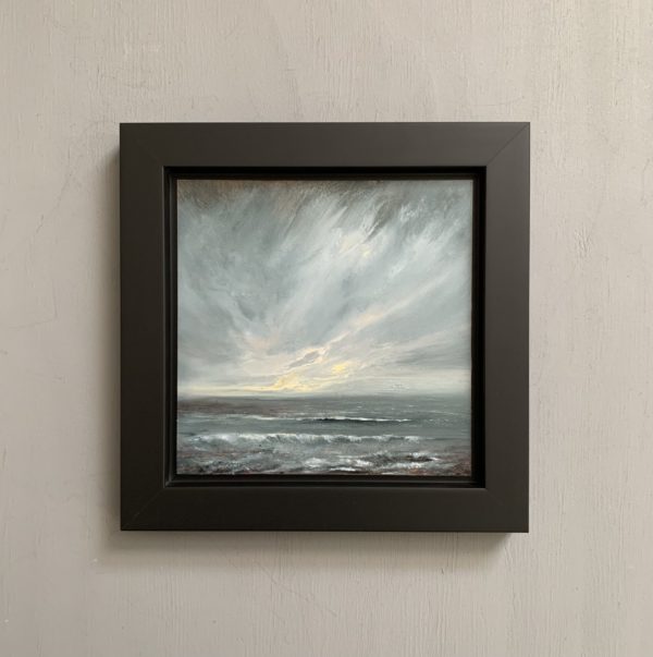 Original seascape oil painting by Tisha Mark, "The Watching" 6"x6" oil on gessobord (2024). Light emerges in a stormy sky over a stormy sea. Shown here in a black float frame.